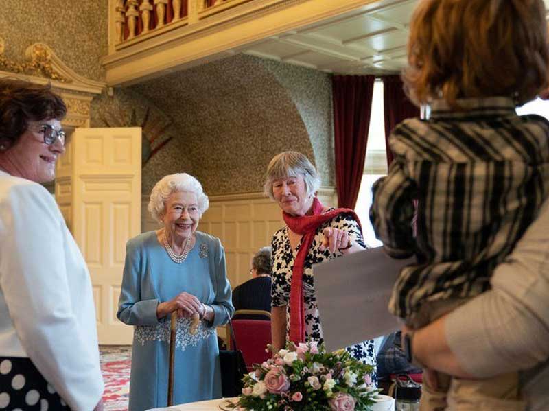 La regina taglia la torta per celebrare il suo Giubileo di platino, tiene il ricevimento per i volontari