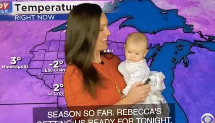 Rebecca Schuld presents weather forecast with her daughter Fiona in her arms. — NDTV
