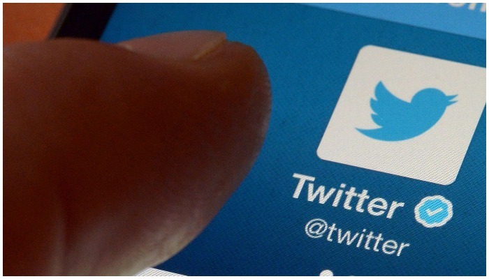 Picture showing person touching the Twitter icon on the screen of their phone — AFP