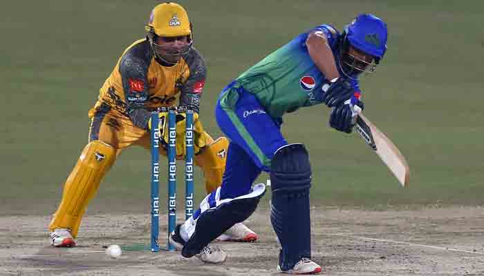 Multan Sultans Shan Masood (R) plays a shot as Peshawar Zalmis Kamran Akmal watches during the Pakistan Super League (PSL) Twenty20 cricket match between Multan Sultans and Peshawar Zalmi at the Gaddafi Cricket Stadium in Lahore on February 10, 2022.-AFP