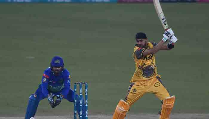 Peshawar Zalmi´s Shoaib Malik (R) plays a shot as Multan Sultans´ captain wicketkeeper Mohammad Rizwan (L) watches during the Pakistan Super League (PSL) Twenty20 cricket match between Multan Sultans and Peshawar Zalmi at the Gaddafi Cricket Stadium in Lahore on February 10, 2022. -AFP