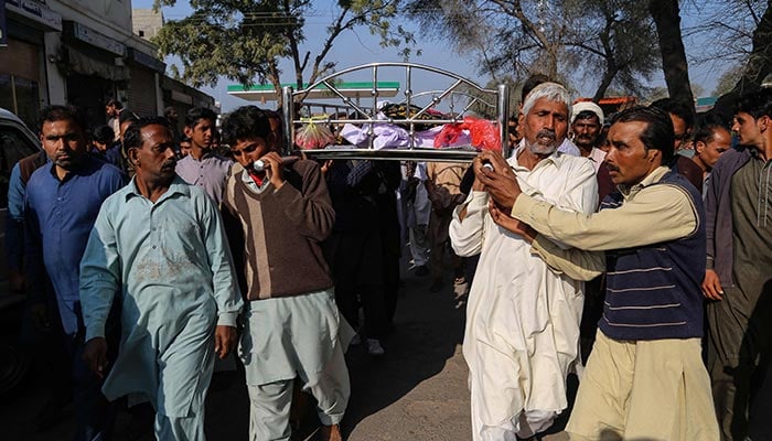 Relatives and locals carry a coffin containing the body of a man for his funeral at Khanewal district on February 13, 2022, who was killed after allegedly an angry mob stoned him to death. — AFP