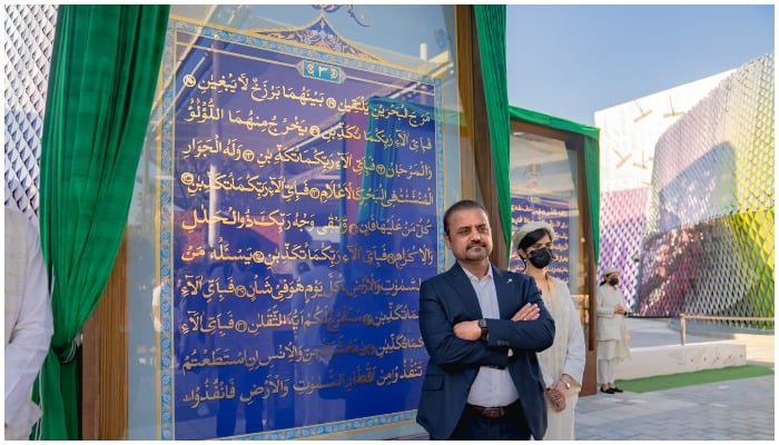 Shahid Rassam standing next to a framed page of the gold-plated Quran at the Pakistan Pavillion of the Dubai Expo 2020. — Twitter/ Shahid Rassam