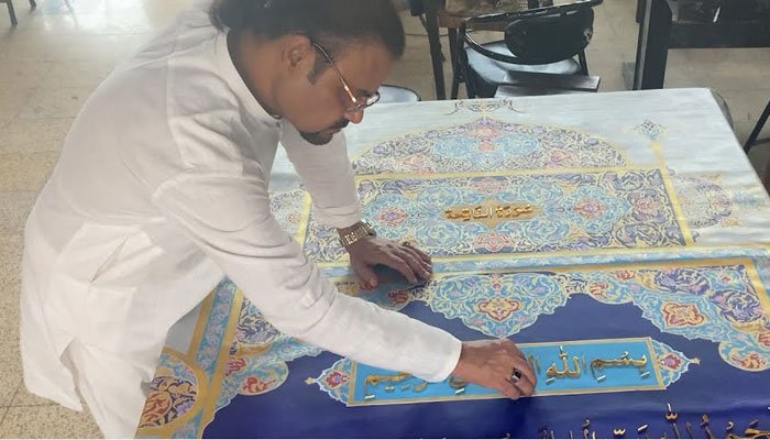 Shahid Rassam working on a page of the world largest Quran. — Twitter/ Shahid Rasssam