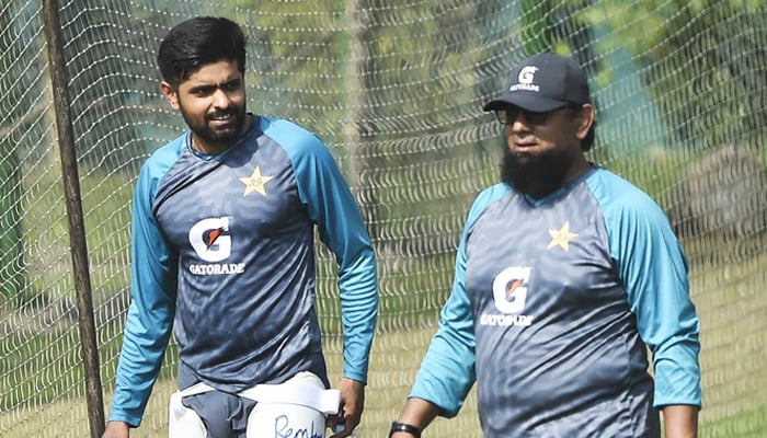 Pakistan’s captain Babar Azam, left, talks to team coach Saqlain Mushtaq during a training session at the Sher-e-Bangla National Cricket Stadium in Dhaka, Bangladesh, on December 2, 2021. — AFP