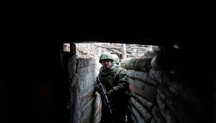 Militants of the self-proclaimed Luhansk Peoples Republic walk in a trench at combat positions near the line of separation from the Ukrainian armed forces outside the settlement of Molodizhne (Molodezhnoye) in the Luhansk region, Ukraine February 17, 2022. &mdash; Reuters