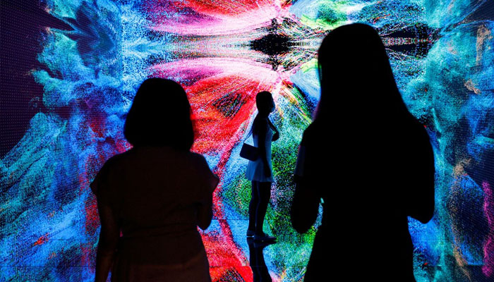 Visitors are pictured in front of an immersive art installation titled Machine Hallucinations - Space: Metaverse by media artist Refik Anadol at the Digital Art Fair, in Hong Kong, China September 30, 2021. REUTERS/Tyrone Siu/File Photo