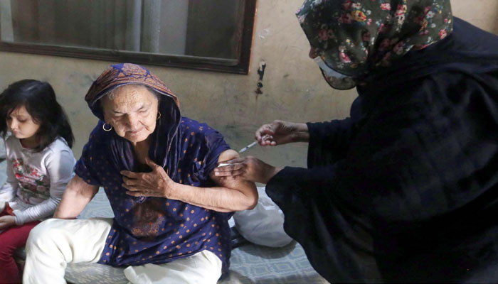 Health worker administrates anti-Covid-19 vaccine to citizens during the coronavirus vaccination door to door campaign, located on Buffer Zone area of Karachi on Wednesday, February 16, 2022. — PPI/File