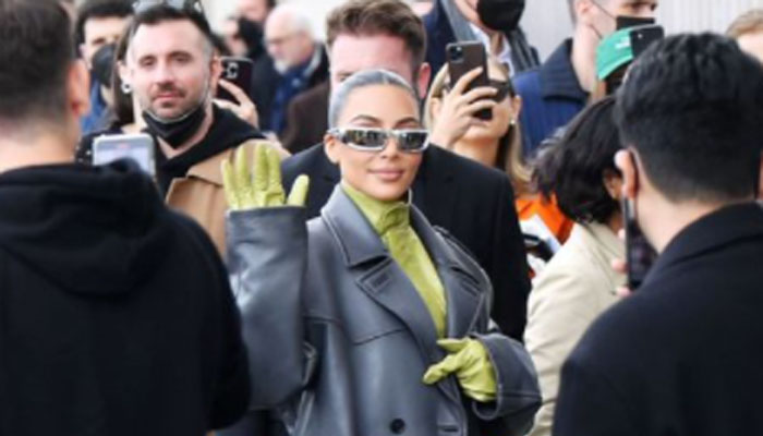 Kim Kardashian watches sister Kendall Jenner on the catwalk at Milan Fashion Week show