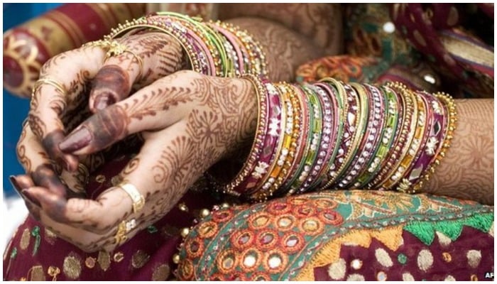 Representational image of a woman wearing bangles and henna — AFP