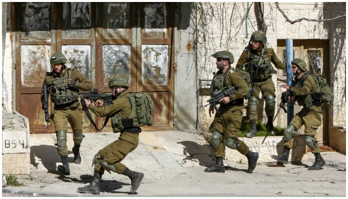 Illustrative. Palestinians wave national flags in front of Israeli soldiers during a protest outside the West Bank village of Tubas, near the Jordan Valley, on January 29, 2020, against US President Donald Trumps peace proposals. — Jaafar Ashtiyeh/AFP