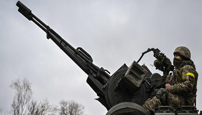 An Ukrainian soldier keeps position sitting on a ZU-23-2 anti-aircraft gun at a frontline, northeast of Kyiv on March 3, 2022. — AFP