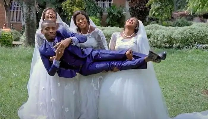 Groom posing with his brides — Screengrab via YouTube/Premium Times