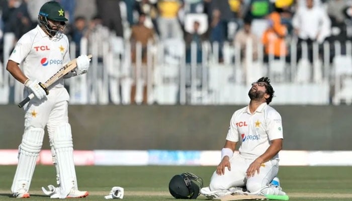 Imam-ul-Haq celebrates after scoring a century as his teammate Azhar Ali watches during the first day of the first Test cricket match between Pakistan and Australia at the Rawalpindi Cricket Stadium. — AFP