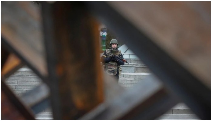 A police guards as anti-tank constructions are seen in central Kyiv, Ukraine March 7, 2022. — Reuters /Gleb Garanich
