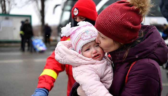 A woman kisses her baby after fleeing from Ukraine to Romania, following Russias invasion of Ukraine, at the border crossing in Siret, Romania, March 7, 2022. — Reuters