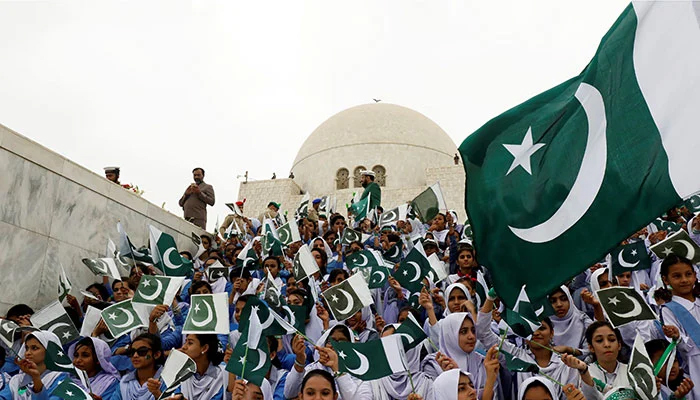 Attendees wave Pakistans national flag while singing national songs at a ceremony to celebrate the country’s 71st Independence Day at the mausoleum of Muhammad Ali Jinnah in Karachi, Pakistan August 14, 2018. — Reuters