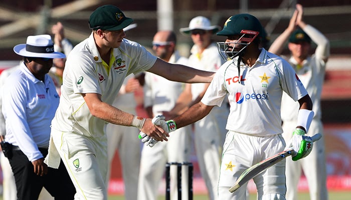 Australias Cameron Green (L) shakes hands his Pakistans captain Babar Azam (R) after Azam´s dismissal during the fifth and final day of the second Test cricket match between Pakistan and Australia at the National Cricket Stadium in Karachi on March 16, 2022. — AFP