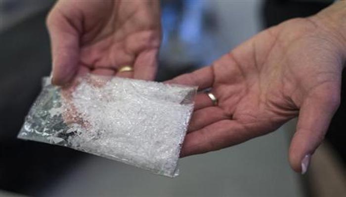 A customs officer holds a bag of the drug methamphetamine confiscated at the German border, before a news conference presenting the annual report of Germanys customs agency, Zoll, at the finance ministry in Berlin, March 22, 2013. — Reuters/Thomas Peter/Files