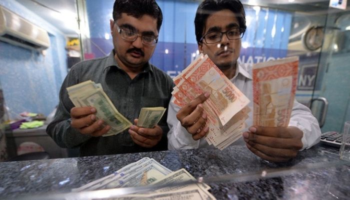 Money dealers count Pakistani rupee and US dollars at a currency exchange in Islamabad. — AFP/File