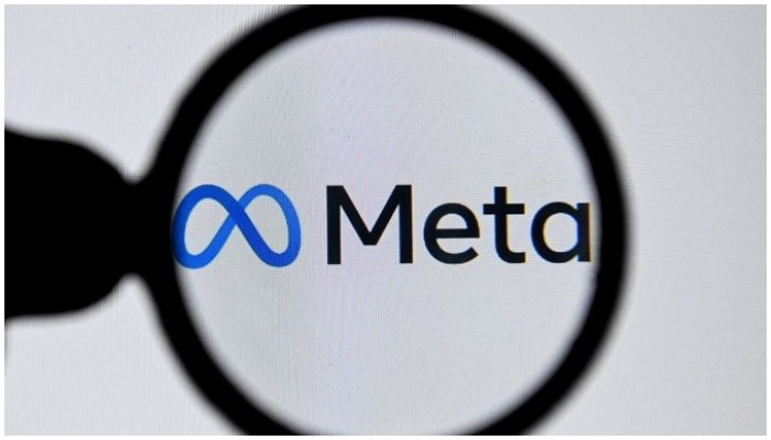 Image showing the logo of Meta as seen through a magnifying glass. — AFP