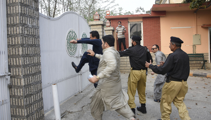 Anggota PTI menendang gerbang Rumah Sindh saat polisi mencoba menghentikannya.  - ON LINE