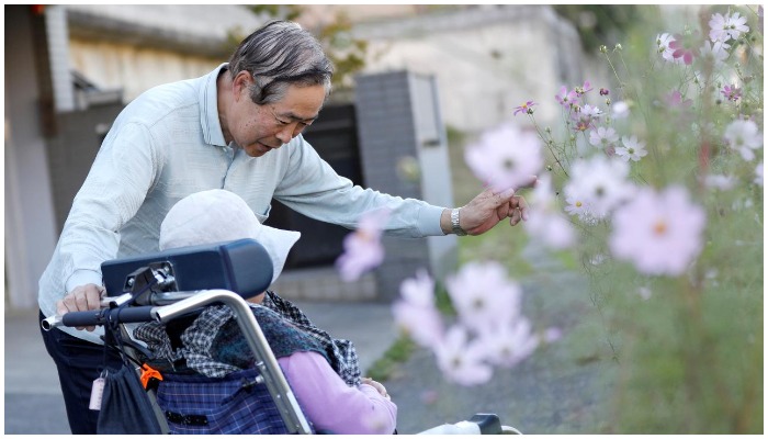 Picture showing a man talking to a wheelchair-bound woman. — Reuters/File.