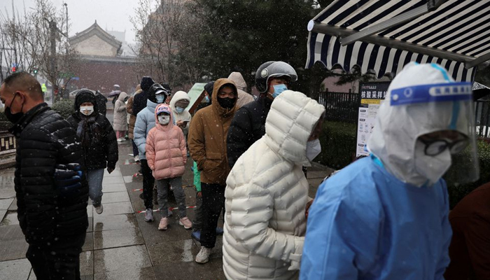 People line up amid snowfall at a mobile nucleic acid testing site, following the coronavirus disease (COVID-19) outbreak, in Beijing, China March 18, 2022. — Reuters