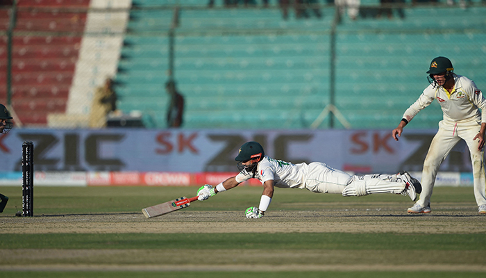 Pakistans Mohammad Rizwan (C) dives to save his wicket during the fifth and final day of the second Test cricket match between Pakistan and Australia at the National Cricket Stadium in Karachi on March 16, 2022. — AFP