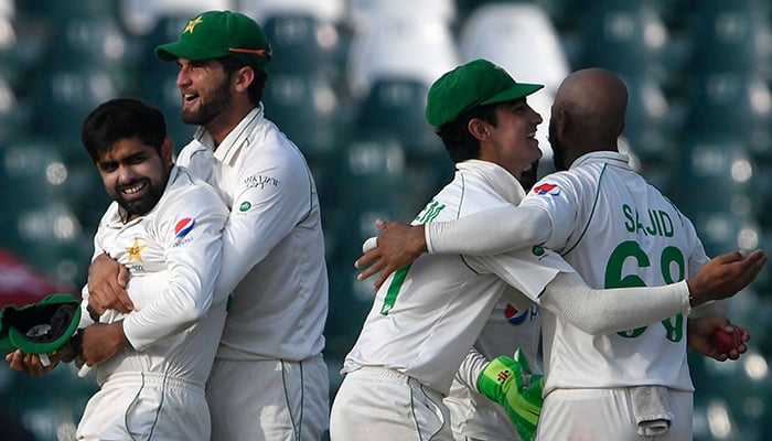Pakistans captain Babar Azam (L) celebrates with teammates after the dismissal of Australias Usman Khawaja (not pictured) during the first day of the third and final Test cricket match between Pakistan and Australia at the Gaddafi Cricket Stadium in Lahore on March 21, 2022. — AFP