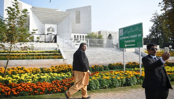 A Pakistani lawyer (R) uses his mobile phone in front of the Supreme Court building in Islamabad on November 28, 2019. — AFP/File