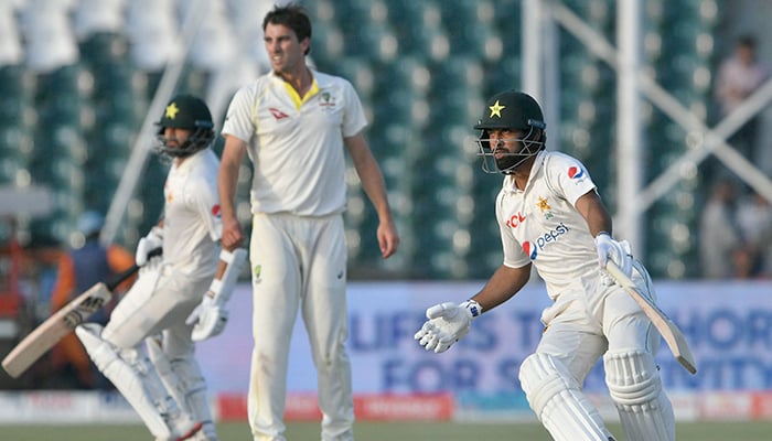 Pakistan´s Abdullah Shafique (R) and Pakistan´s Azhar Ali (L) run between the wickets during the second day of the third and final Test cricket match between Pakistan and Australia at the Gaddafi Cricket Stadium in Lahore on March 22, 2022. — AFP