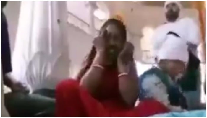 Screengrab of the video showing a woman being beaten up by men for allegedly smoking at the Golden Temple in Amritsar. — Twitter/Singh Varun