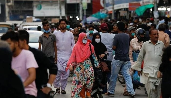 Women wearing mask shop in Karachi. Photo: Reuters