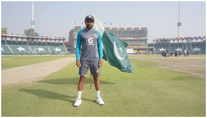 Pakistan skipper babar Azam poses for a picture with Pakistani flag fluttering behind him. Photo: Twitter/ @TheRealPCB