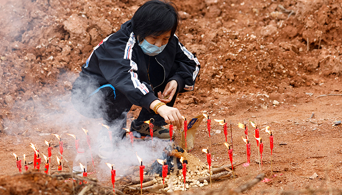 A woman surnamed Liang, 60, takes part in a Buddhist ceremony in honor of the victims in a field close to the entrance of Simen village, near the site where a China Eastern Airlines Boeing 737-800 plane flying from Kunming to Guangzhou crashed, in Wuzhou, Guangxi Zhuang Autonomous Region, China March 22, 2022. — Reuters