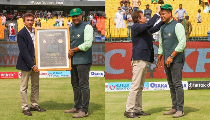 Former Pakistan captain Waqar Younis gets his commemorative cap and plaque at Gaddafi Stadium in Lahore, on March 23, 2022. — PCB