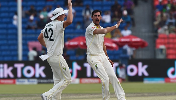 Australias Mitchell Starc (R) celebrates with teammates after dismissing Pakistans Babar Azam (not pictured) during the third day of the third cricket Test match between Pakistan and Australia at the Gaddafi Cricket Stadium in Lahore on March 23, 2022. — AFP