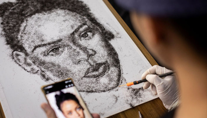 Artist and Filipino seafarer Jesstoni Garcia works on a portrait of Rihanna, made out of human hair, in San Juan City, Philippines. Photo— REUTERS/Eloisa Lopez
