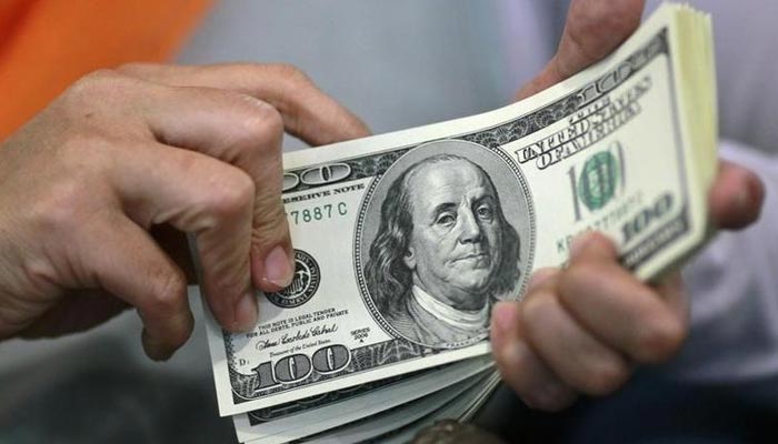 A currency dealer counting $100 notes. — Reuters/File