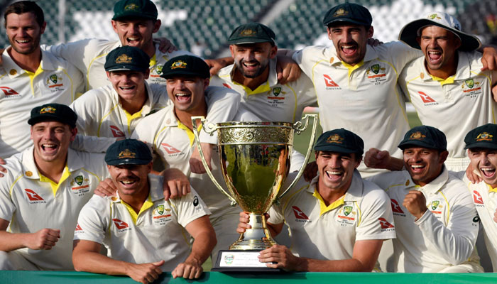 Australias players pose with the trophy after winning the third and final Test cricket match against Pakistan, claiming historic series win at the Gaddafi Cricket Stadium in Lahore on March 25, 2022. — AFP