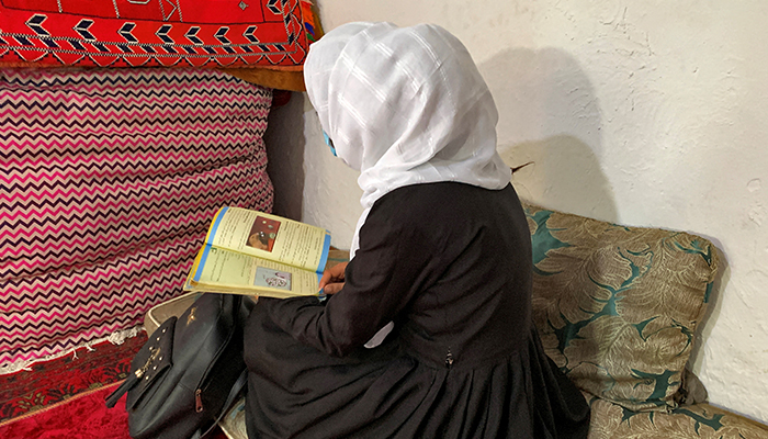 An Afghan schoolgirl reads from her book inside a house in Kabul, Afghanistan, March 23, 2022. — Reuters