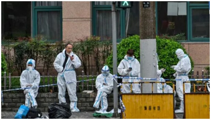 Workers in Shanghai wearing protective gears. AFP/File.