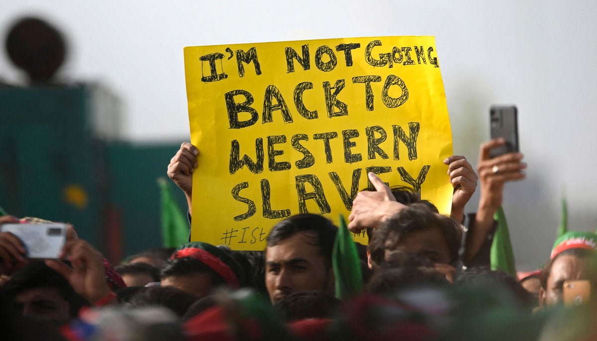 A supporter holds a placard during a rally being addressed by Pakistans Prime Minister Imran Khan, in Islamabad on March 27, 2022. — AFP