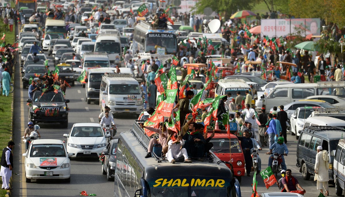 Activists and supporters of ruling PTI party arrive to attend a rally in Islamabad on March 27, 202. — AFP