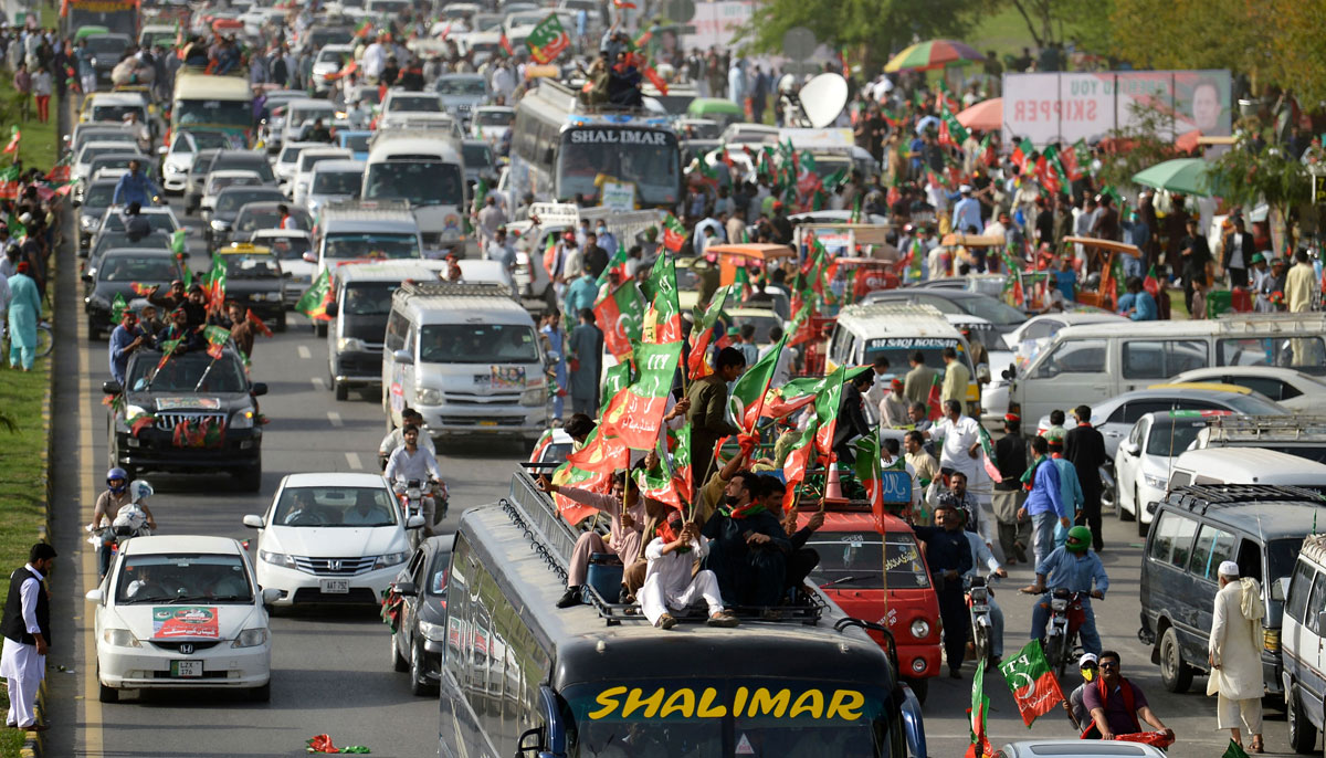 Activists and supporters of ruling PTI party arrive to attend a rally in Islamabad on March 27, 202. — AFP