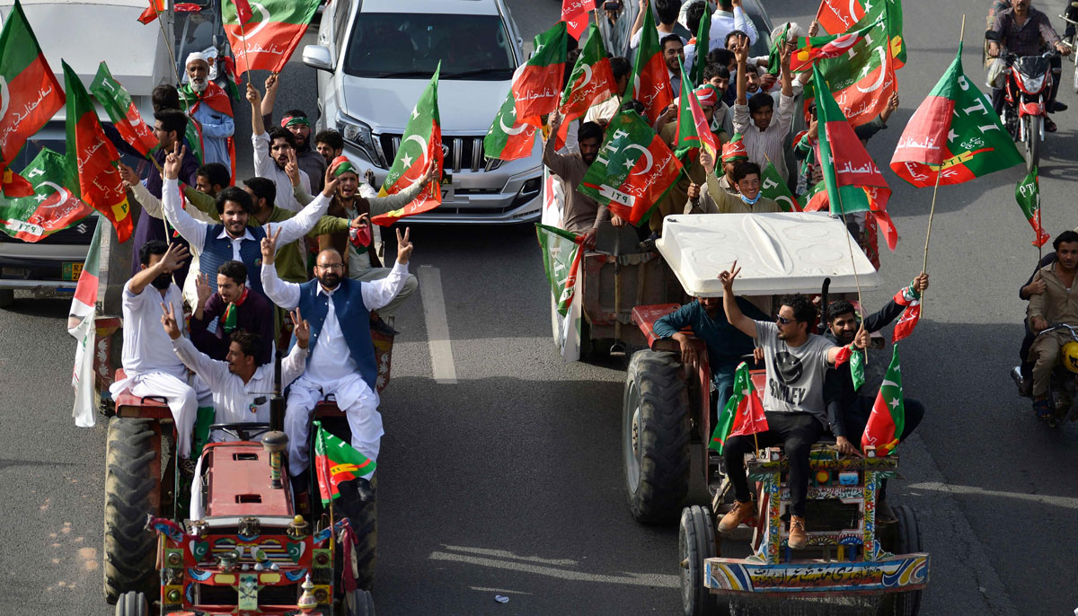 Activists and supporters of ruling PTI party arrive to attend a rally in Islamabad on March 27, 2022.— AFP