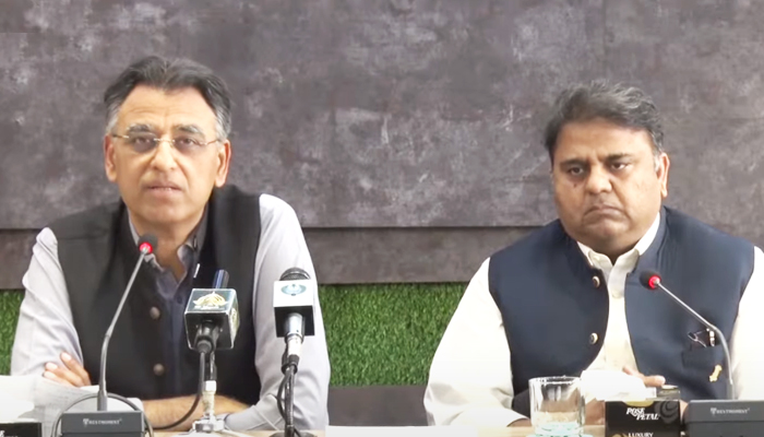 Federal Minister for Planning, Development, and Special Initiatives Asad Umar (left) addressing a press conference along with  Information Minister Fawad Chaudhry (right) in Islamabad, on March 29, 2022. 1 YouTube/HumNewsLive