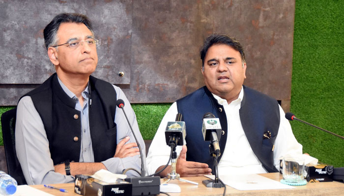 Federal Minister for Planning, Development, and Special Initiatives Asad Umar (left) addressing a press conference along with  Information Minister Fawad Chaudhry (right) in Islamabad, on March 29, 2022. — PID