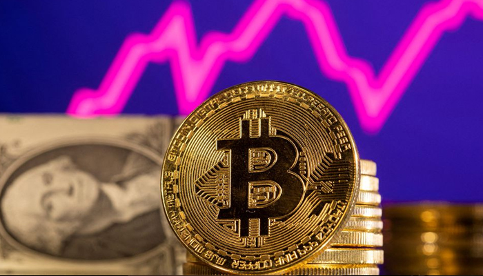 A representation of the cryptocurrency Bitcoin is seen in front of a stock graph and the US dollar in this illustration taken, on January 24, 2022. — Reuters